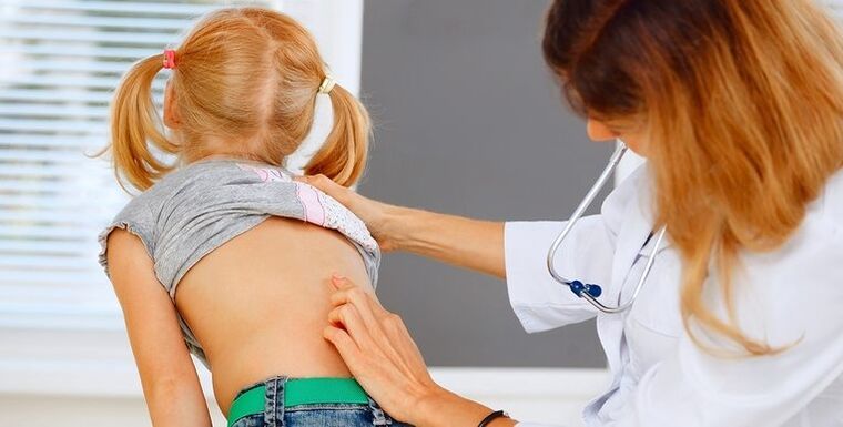 پزشک در حال معاینه کمر کودک از نظر کمردرد